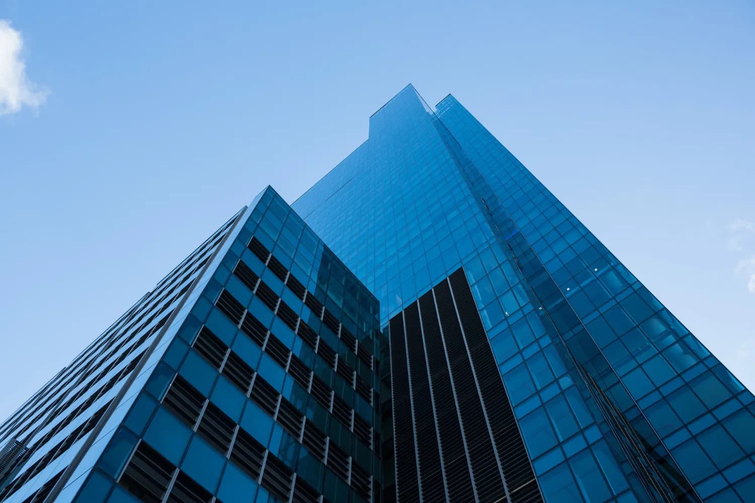 Looking up at the glass facade of a modern office building